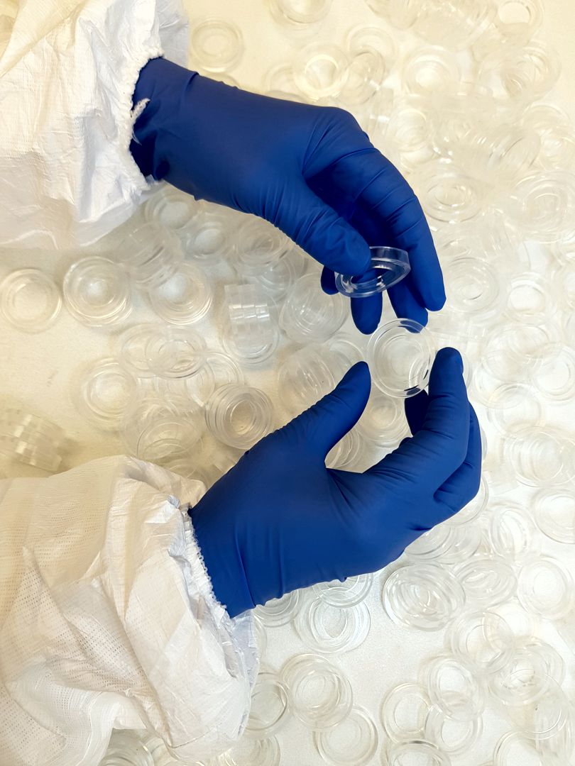 Gowned cleanroom operator handling silicone components